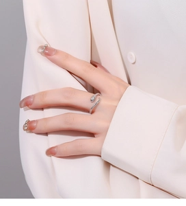 Macro shot of silver snake-shaped ring with pavé-set cubic zirconia on female hand