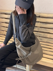 Detail of grey gingham crescent hobo bag with drawstring pleats and adjustable strap