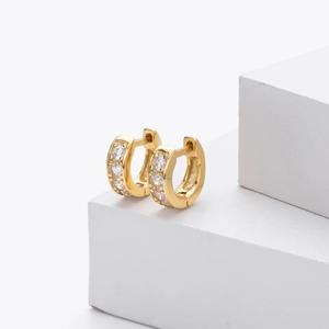 Macro detail of gold-plated small hoop earrings with paved cubic zirconia stones