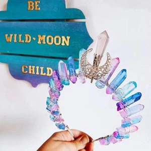 Macro detail of handmade natural crystal crown with silver moon and colorful stone pillars