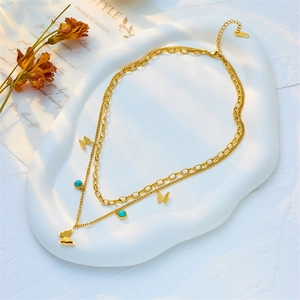 Double-layer butterfly necklace in gold finish with turquoise beads on elegant tray