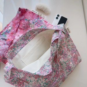 Detail of floral cotton tote bag showing interior lining, inner pocket, and magnetic clasp