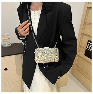 Close-up of a silver liquid metal textured clutch bag with a slim metal chain strap