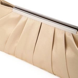 Macro shot of elegant pleated champagne satin fabric with silver metal clasp on evening clutch