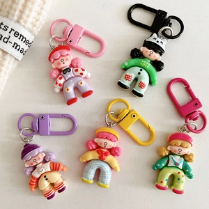 Flat lay of colorful cartoon girl figurines with matte metal lobster clasps for bags