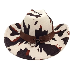 Detail of western cow print felt hat featuring brown leather band and bow decoration