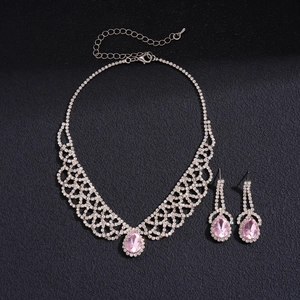 Detail of luxury teardrop pink gemstone necklace and earrings set on black texture