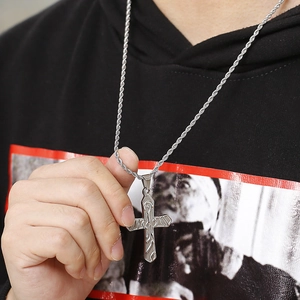 Detail of silver titanium steel cross pendant with texture on a twisted rope chain
