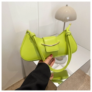 Detail of neon green crescent shoulder bag with gold hardware and knot strap