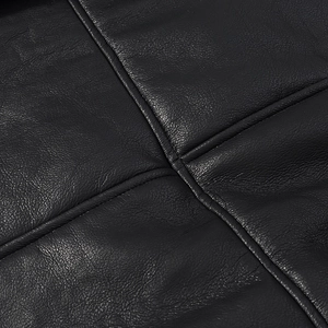 Detailed close-up of premium black lychee texture leather with precise cross-stitch sewing