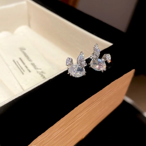 Macro shot of silver rabbit earrings featuring claw-set cubic zirconia on jewelry box