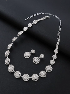 Detail shot of silver bridal jewelry set with sparkling floral rhinestone necklace and earrings