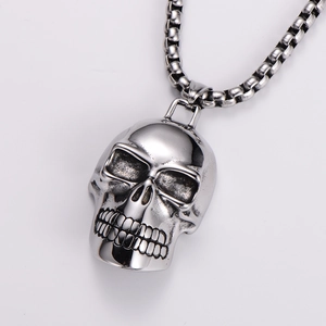 Close-up of polished silver skull pendant with box chain in punk hip-hop style