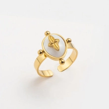 Close-up of a gold vintage open ring with a white oval inlay and center star motif