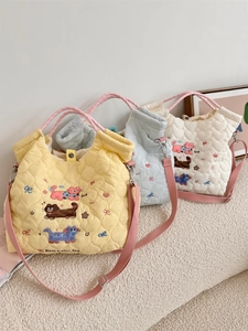 Close-up of quilted tote bags featuring cute cat embroidery and adjustable straps