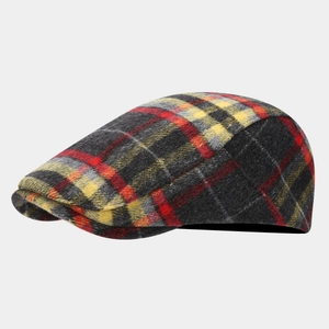 Detail of red and yellow plaid flat cap showing thick wool blend fabric texture