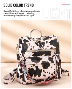 Detail of cow print backpack with lychee grain texture and colorful striped strap