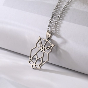 Macro shot of silver hollow geometric owl pendant on stainless steel chain necklace