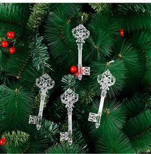 Four transparent vintage key-shaped ornaments hanging on a festive Christmas tree