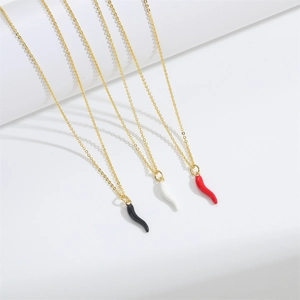 Trois colliers dorés avec pendentifs piment noirs, blancs et rouges sur fond blanc