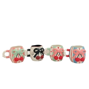 Set of four ceramic cherry bow mugs with embossed patterns in various colors