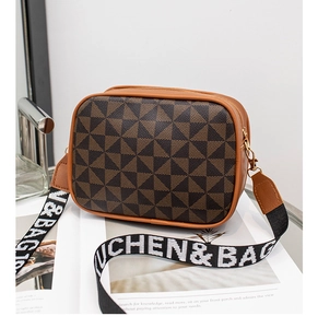 Detail of caramel crossbody camera bag with geometric pattern and wide jacquard strap
