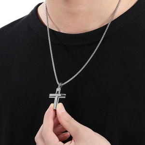 Close-up of polished silver double-layered cross pendant necklace on a black shirt