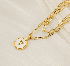 Vue détaillée du collier double épaisseur doré avec pendentif lettre Y et chaîne trombone