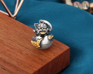 Détail macro du pendentif bête en argent antique avec accents dorés sur bois