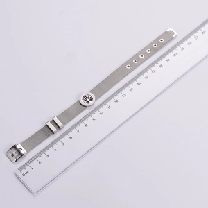 Macro detail of stainless steel mesh bracelet with tree of life pendant and ruler scale