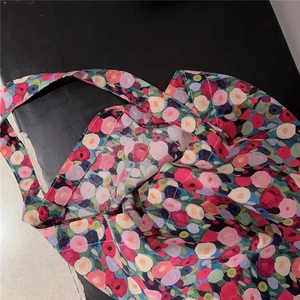 Flat lay detail of floral canvas tote bag showing colorful flower print and sturdy straps