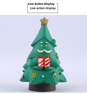 Close-up of cute resin Christmas tree figurine with Santa face holding a gift box