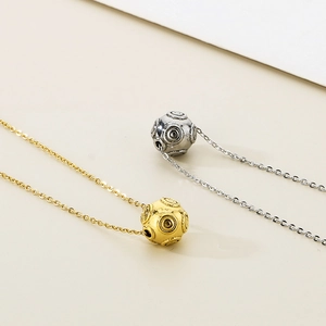 Minimalist round ball pendant necklace in gold and silver with concentric circle texture