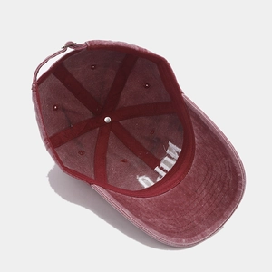 Detail view of the washed burgundy baseball cap showing inner stitching and metal buckle