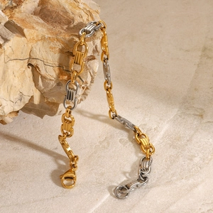 Détail d'un bracelet gourmette bicolore or et argent sur support en pierre naturelle