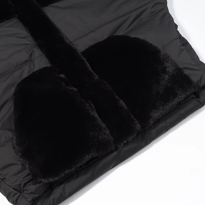 Detail of a plush faux fur pocket on a glossy black quilted jacket with ribbed texture
