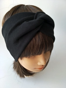 Detail of a black knitted ribbed headband for kids featuring a stylish twisted knot design