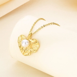 Detail of gold leaf pendant with white pearl on an O-chain necklace for women
