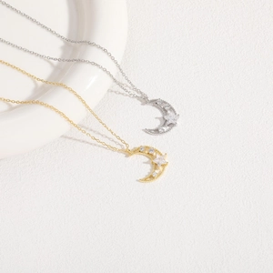 Detailed view of 14K gold and silver star moon pendants with cubic zirconia inlay