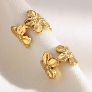Vue macro des boucles d'oreilles fleurs vintage plaquées or 18 carats sur le cartilage