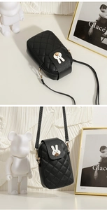 Close-up of black quilted mobile phone bag with cute white rabbit and gold hardware