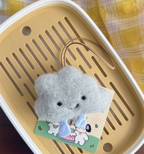 Detail view of a fluffy gray plush cloud charm with blue legs and a premium leather strap