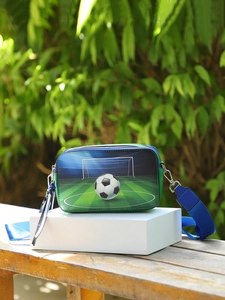 Detailed view of square crossbody bag with soccer print on a white display pedestal