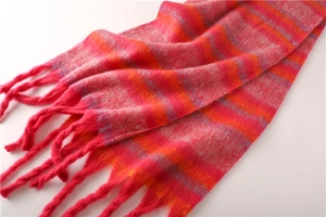 Close-up of pink and orange striped knit scarf showing soft texture and tassel details