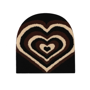 Detail of knit beanie featuring a heart pattern in black, brown, and beige tones