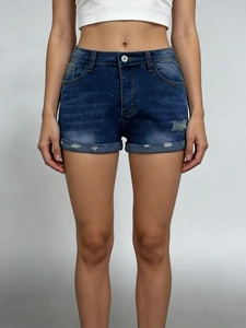Detail of high waist denim shorts with distressed ripped effects and rolled hem finishes