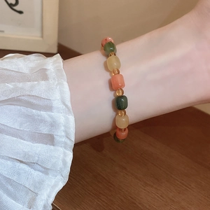 Close-up of colorful beaded Bodhi seed bracelet worn on wrist with elegant wood background