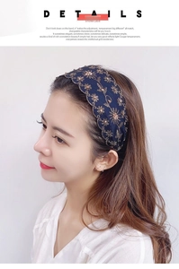 Detalle de diadema azul oscuro con bordado floral dorado y pequeñas cuentas blancas