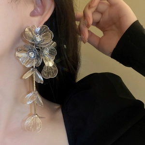 Silver hollow flower earrings with rhinestone tassels shown on a model profile