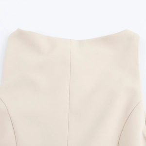 Detailed view of the sleeveless round neck beige dress featuring refined stitching details